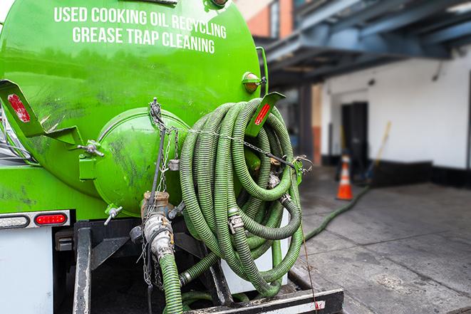 a grease trap being pumped by a sanitation technician in Amherst, OH